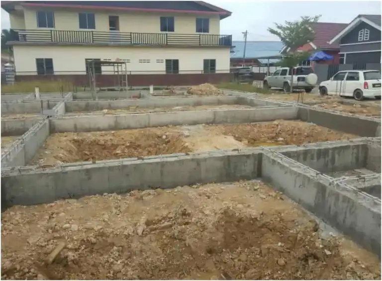 Peringkat asas rumah RumahHQ — rasuk tanah konkrit sudah dituang membentuk susun atur bilik, dengan tanah di dalam petak menunggu ditambak dan dipadatkan